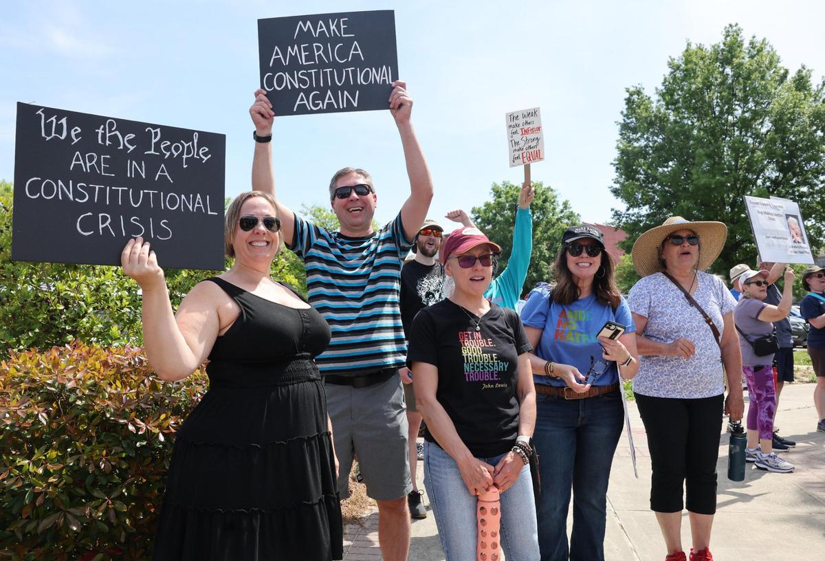Demonstrators smile at traffic Saturday at the York County Rising protest in downtown Rock Hill.