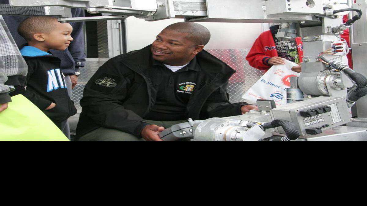 
Rock Hill Police Department bomb technician Keenan McCrorey shows a bomb robot to Jevan Harfield, 4, Saturday at the Come-See-Me Everything Trucks! event at First Baptist Church of Rock Hill.
