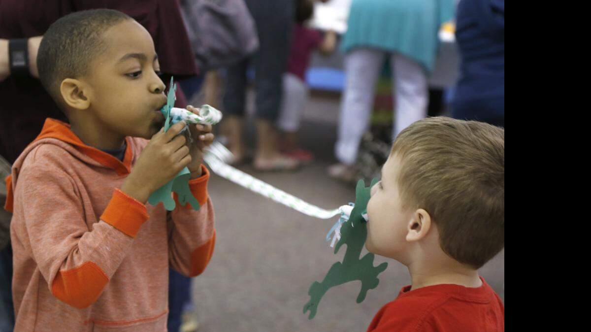 
The Jumping Jeepers Frog Crafts Come-See-Me event was held Monday morning at the York County Library in Rock Hill. Austin Smith, 6, left, and Korbin Lee, 5, play with the froggie fly catchers they made.
