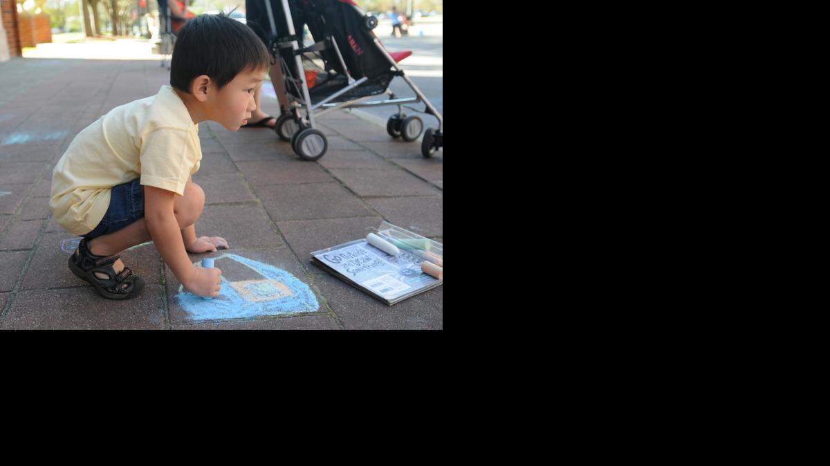 
Eben Whisonant works on his chalk creation at Come-See-Me’s Chalk on Main. 
