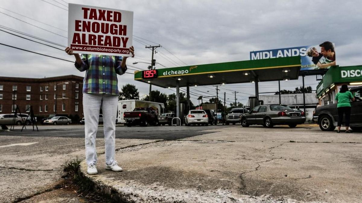 A protestor holds a sign at El Cheapo gas station on Bull Street in May 2015, where anti-gas tax group Americans for Prosperity paid for a portion of customers’ gas to illustrate how much money South Carolinians save without a gas tax increase.