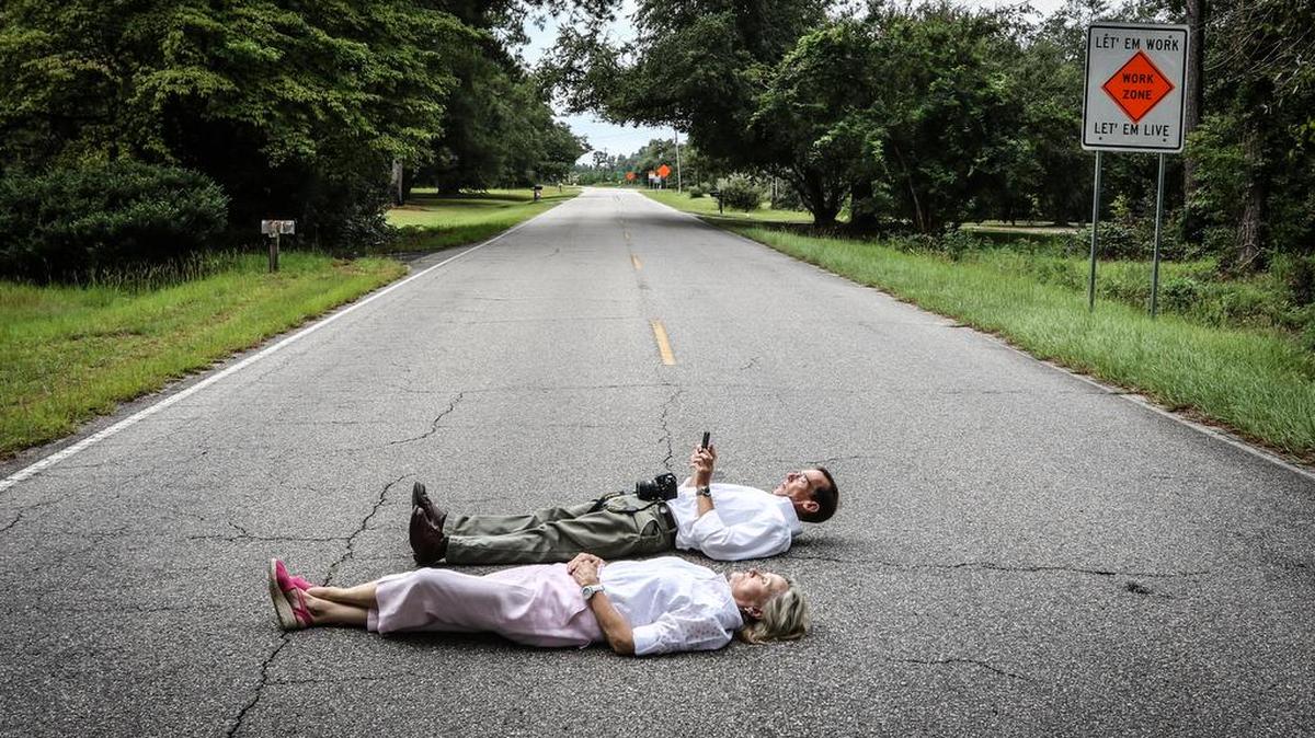 Nancy Cave and Dana Beach lay in the middle of S.C. 51 during rush hour and time how long it takes for a car to disturb them. The rural Florence County road will be turned into a five-lane highway, with the state contributing $340 million.