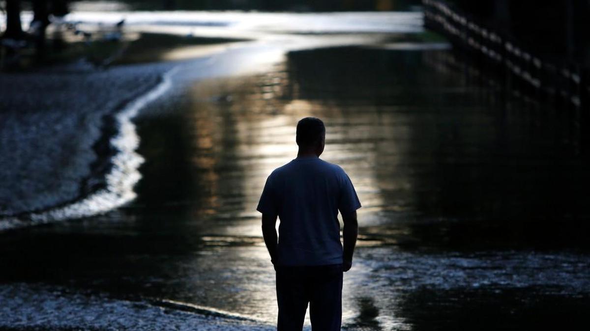 A resident looks down Mayfield St. as the Ashley river flood waters rise in the Ashborough subdivision near Summerville in October.