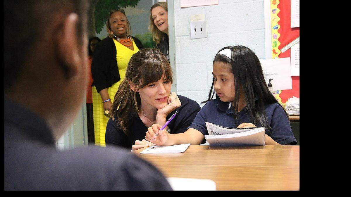 
While visiting Dominque Wells’ third grade class, Jennifer Garner spends time talking with 9-year-old Yesenia Delacruz as she completes her work. Principal Lei Washington and Save The Children state director of programs Anna Hardway watch from the doorway. 

