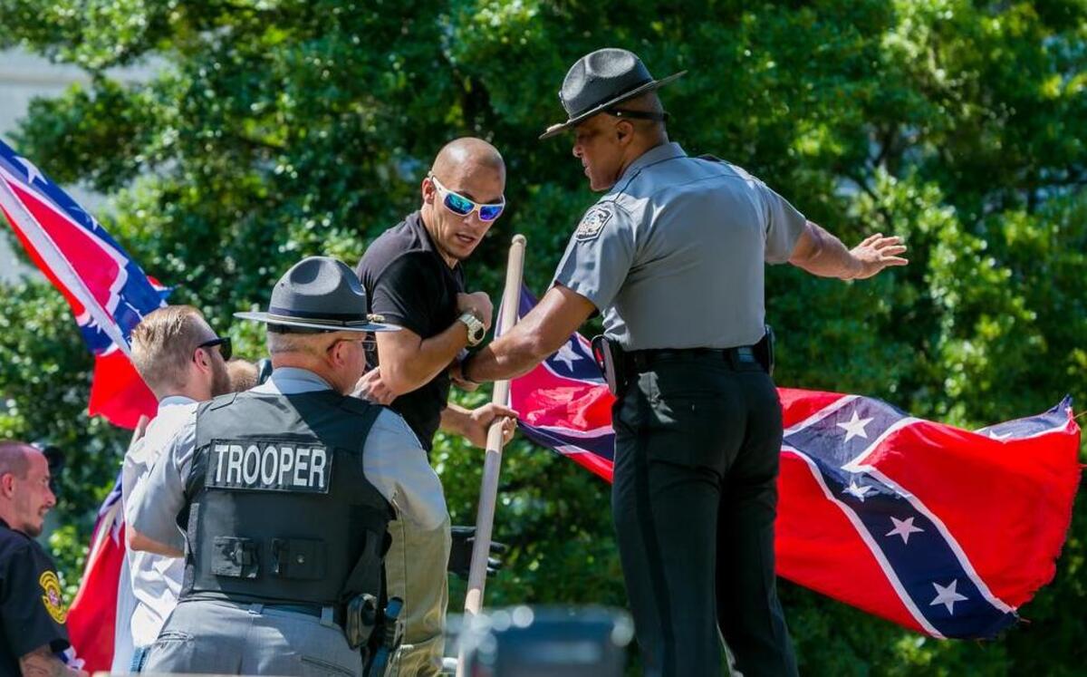 
A law enforcement officer holds back a member of the KKK from going after a someone in the crowd during a KKK rally at the Statehouse in Columbia on July 18.
