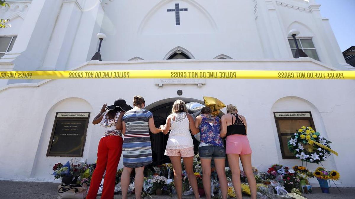 
Women pray together Thursday at a makeshift memorial on the sidewalk in front of the Emanuel AME Church in Charleston.

