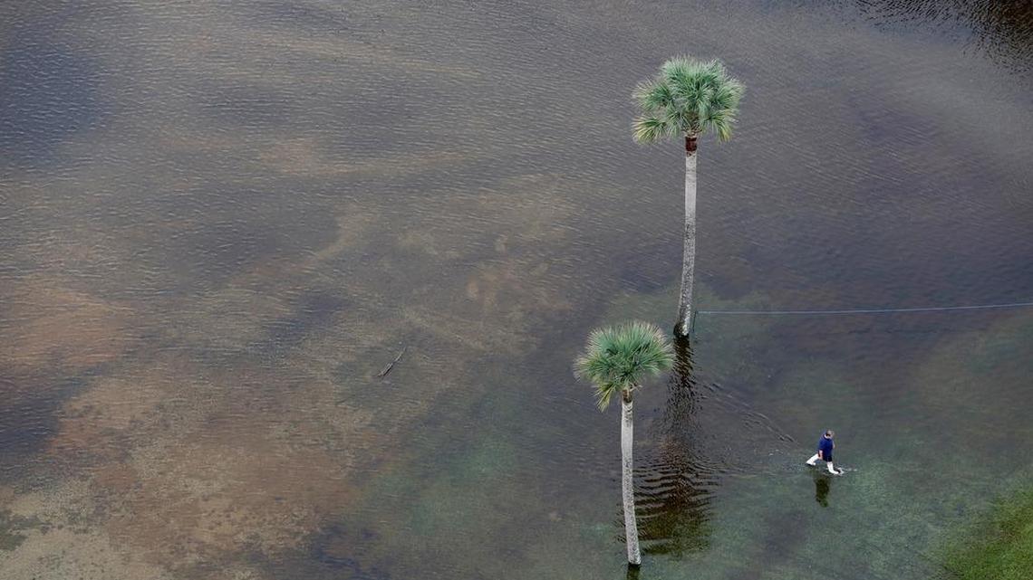 
A man makes his way through floodwaters in the parking lot of The Citadel Beach Club on Isle of Palms on Monday.
