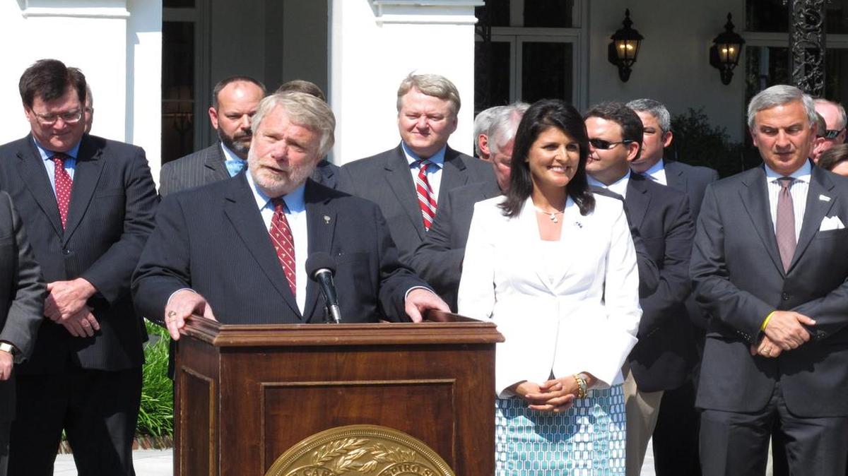 
S.C. Commerce Secretary Bobby Hitt, at podium, talks about Volvo’s announcement it will build its first plant in North America in Berkeley County as Gov. Nikki Haley listens on Monday. 

