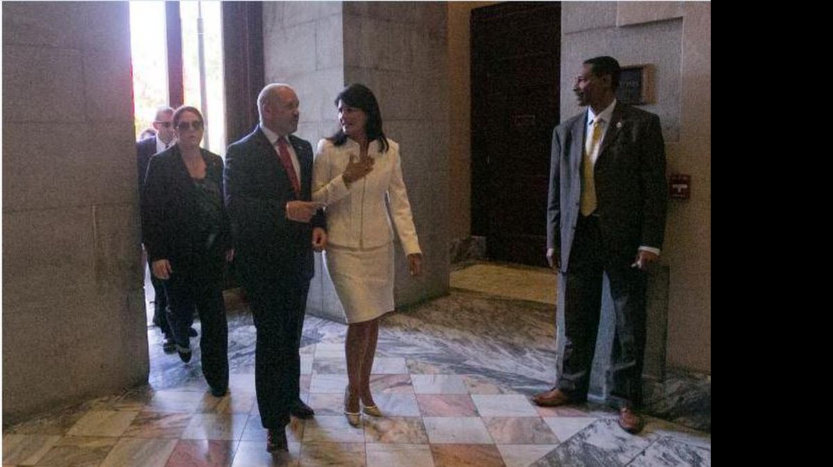 
Gov. Nikki Haley, with husband Michael, enter the S.C. State House after a ceremony that removed the Confederate battle flag from the grounds Friday.
