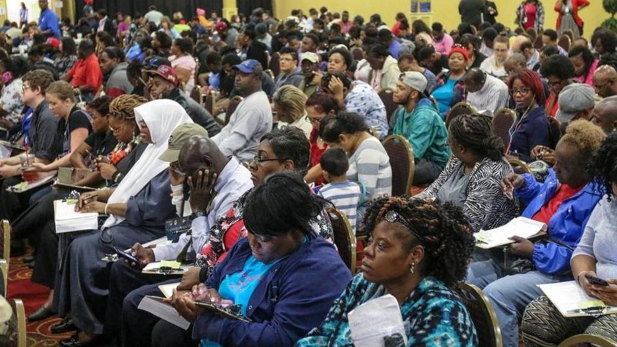 People impacted by the flood wait to apply for food assistance at a processing center at The Word of God Church and Ministries.