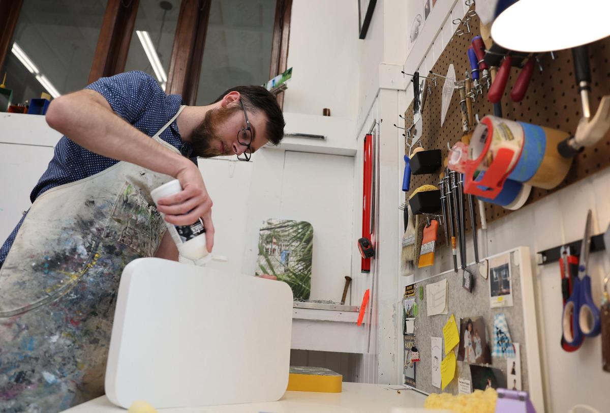 Dylan Bannister, an artist who has studio space at the Tom S. Gettys Center, works on a project Tuesday.