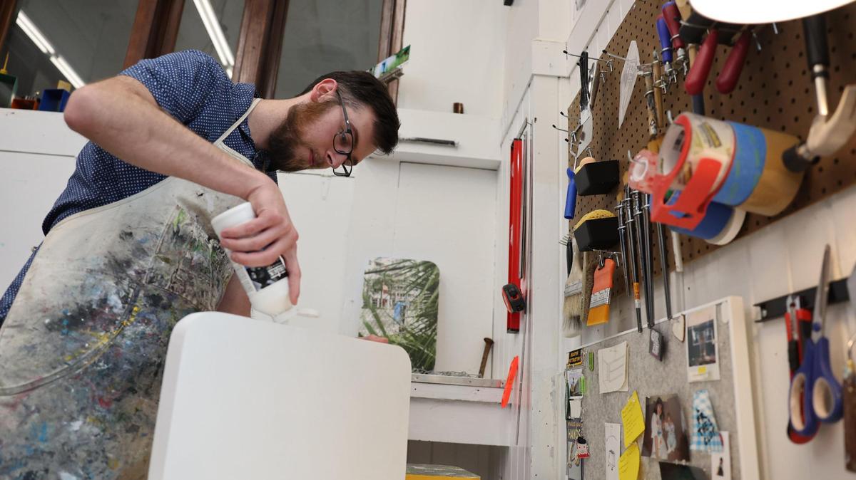 Dylan Bannister, an artist who has studio space at the Tom S. Gettys Center, works on a project Tuesday.