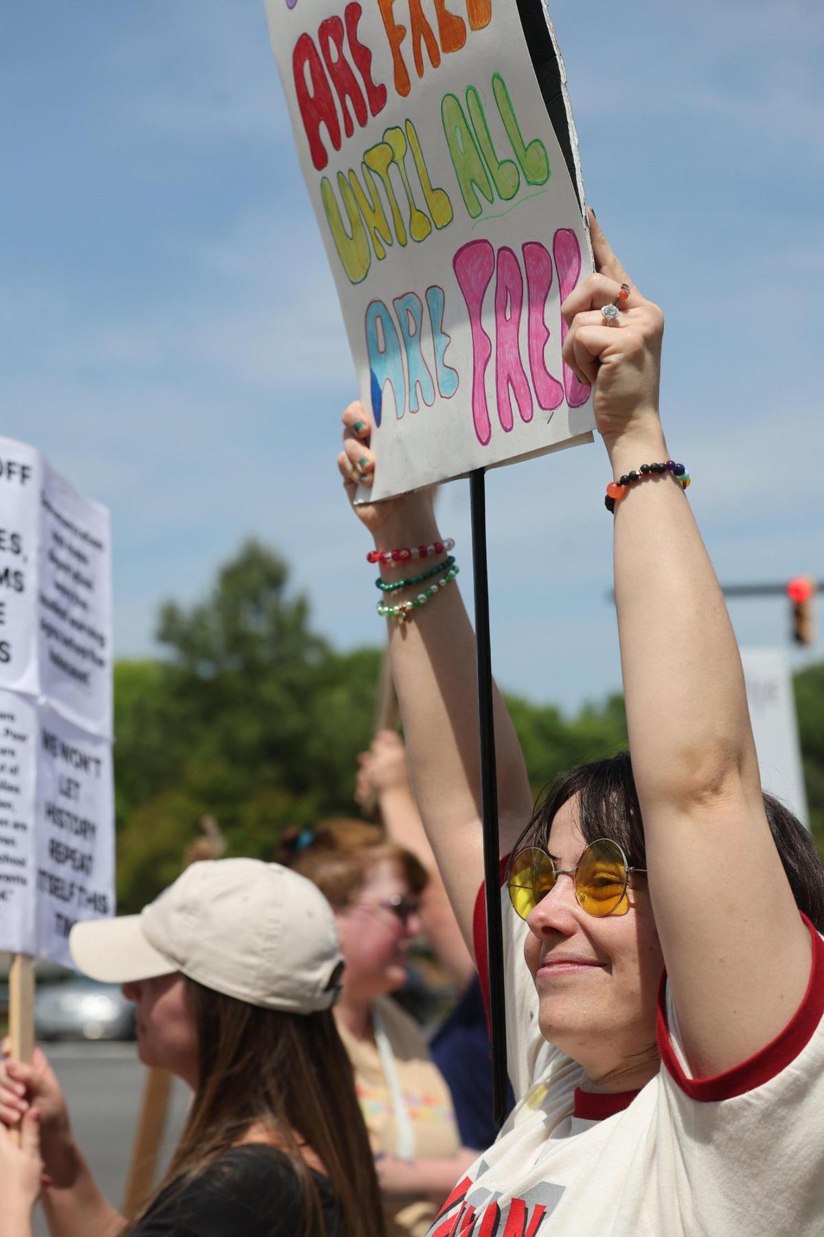 A protestor holds a sign towards traffic on Dave Lyle Blvd. Saturday at the York County Rising demonstration.