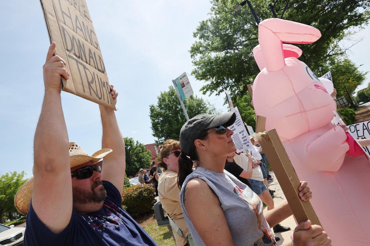 Protestors hold signs Saturday at the York County Rising demonstration in downtown Rock Hill.