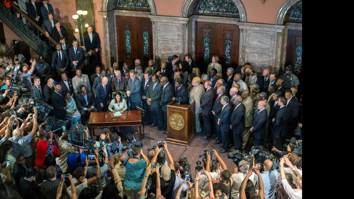
Gov. Nikki Haley signs the law to remove the Confederate battle flag from the front of the Statehouse in Columbia, S.C., on Thursday. The flag is set to come down at 10 a.m. today, after a 13-hour argument in the state’s House.


