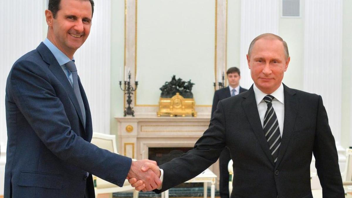 Russian President Vladimir Putin, right, shakes hand with Syrian President Bashar Assad.