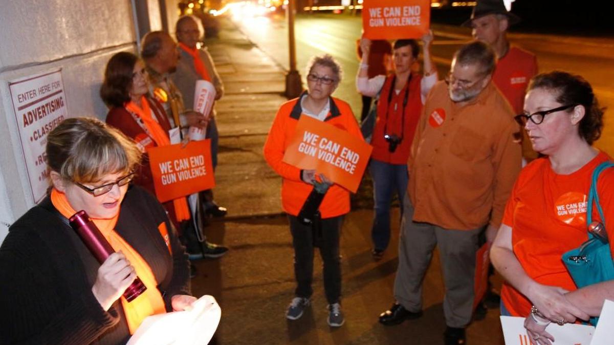 A group of residents walked from the Episcopal Church of Our Saviour in downtown Rock Hill to The Herald Monday night to deliver letters to the editor in support of better gun laws. Diane Rudulph, left, reads her letter to the editor in front of The Herald on West Main Street.