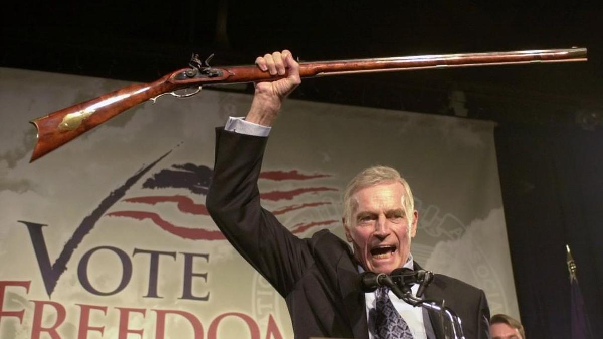 
In this 2002 file photo, National Rifle Association President Charlton Heston holds up a rifle as he addresses gun owners during a “get-out-the-vote” rally in Manchester, N.H. Gun interests, wary of any possible limits on weaponry, have successfully lobbied for limitations on government research and funding into the causes of gun violence, and which policies work best against it.
