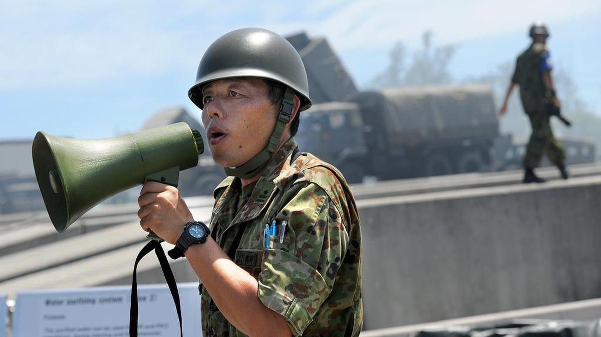 A Japanese soldier explains a water filtration center during a joint exercise between the U.S. Marines and the Japanese Ground Self-Defense Force in Okinawa. Growing defense spending will enable the construction of a headquarters for a new Japanese Air Self-Defense Force squadron.
