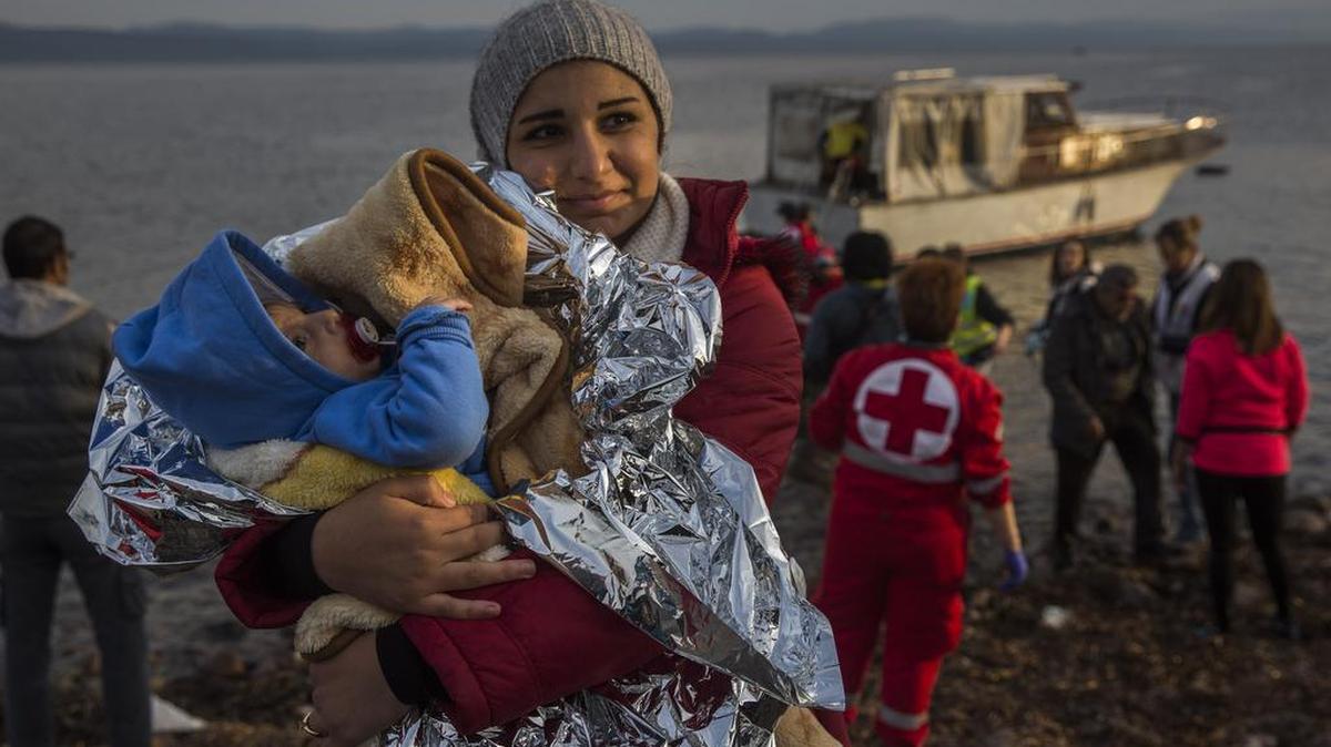 A Syrian woman holds her baby after their arrival on a small boat from the Turkish coast on the northeastern Greek island of Lesbos.