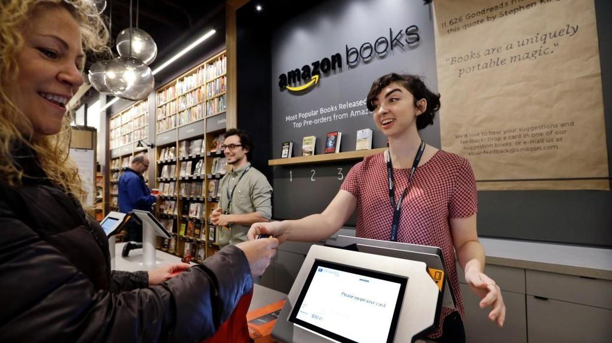Customer Kirsty Carey makes one of the first purchases Tuesday with clerk Marissa Pacchiarotti at the opening day for Amazon Books, the first brick-and-mortar retail store for online retail giant Amazon in Seattle.