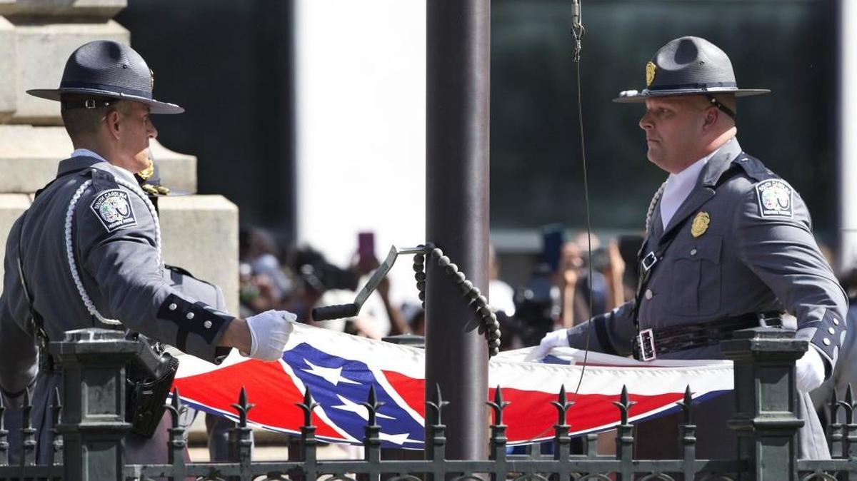 An honor guard from the Highway Patrol lowers the Confederate battle flag as it is removed from the Capitol grounds on July 10.