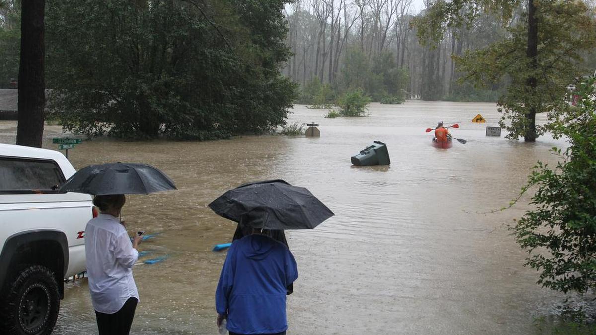 
Neighbors watch as John Wienges and Will Lenski rescue their neighbors from their flooded homes along Gills Creek. The river flooded homes along Timberlane Drive and Whispering Pines Circle in Columbia.
