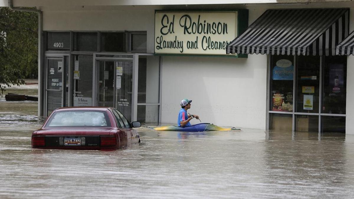 
Jordan Bennett of Rock Hill paddles up to a flooded store in Columbia on Sunday. The rainstorm that drenched the U.S. East Coast brought more misery to South Carolina, cutting power to thousands, forcing hundreds of water rescues and closing many roads because of floodwaters.
