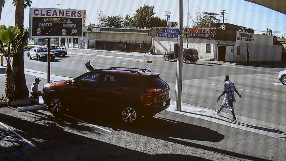In this image made from security video footage provided by the Los Angeles County Sheriff, a man, right, walks with a gun in his hand Saturday, Dec. 12, 2015 in Lynwood, Calif. Two deputies fired 33 bullets at the man after he refused to drop the gun and walked across a busy street to a filling station where a family was pumping gas, homicide Cpt. Steven Katz said. He died at the scene Saturday morning.