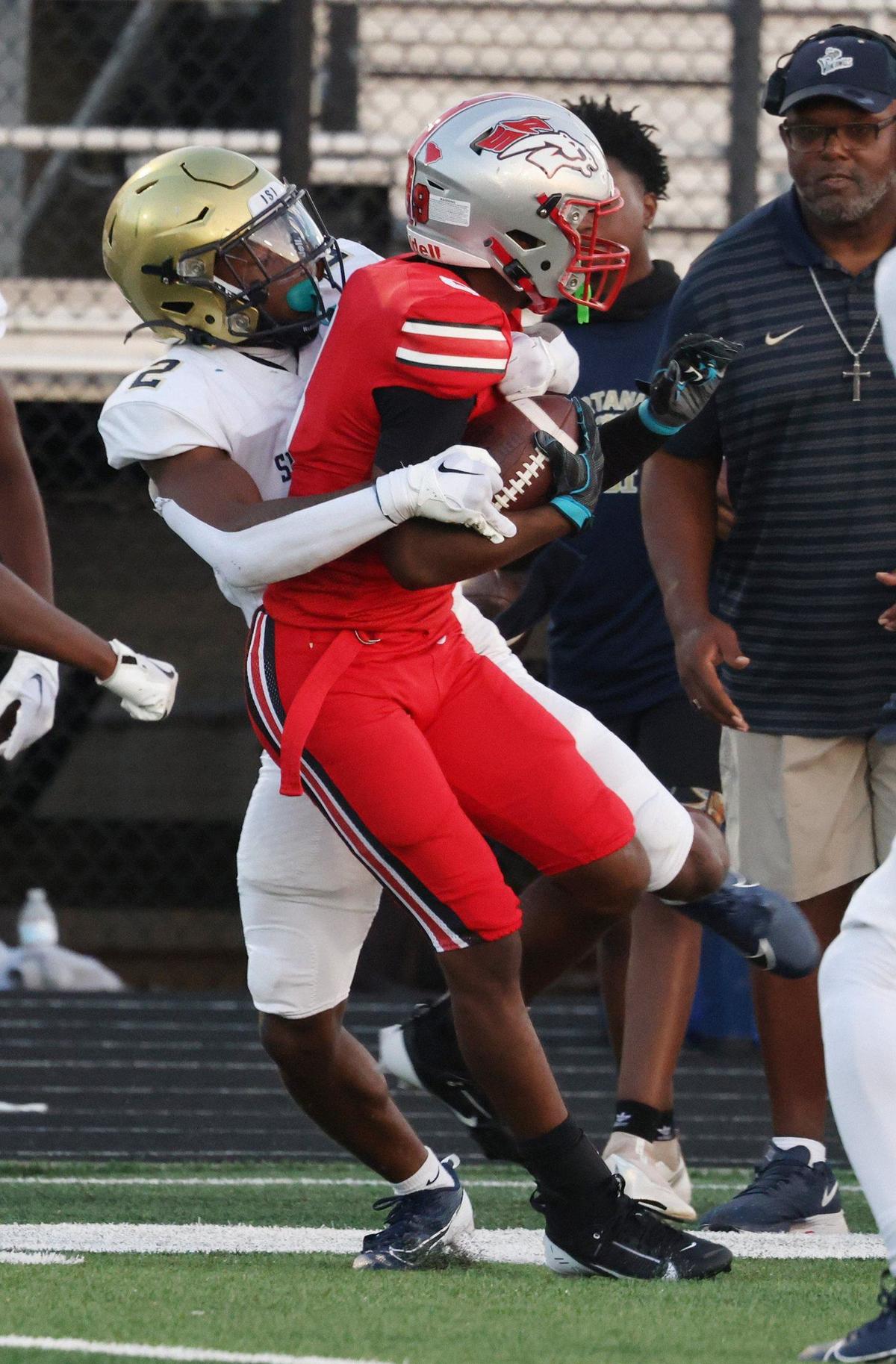 South Pointe’s J’Zavien Currence, right, is tackled by Spartanburg’s Quincy Haywood II Friday in Rock Hill.