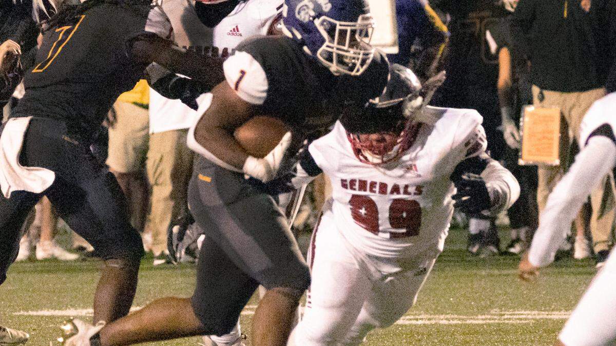 Northwestern’s Turbo Richard carries the ball past Wade Hampton’s Chanze Hilton-Parker (99).