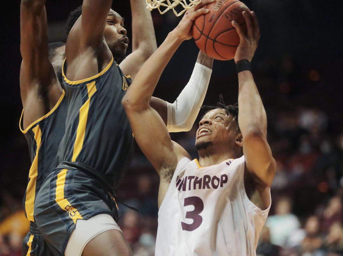 Winthrop’s Michael Anumba takes the shot against NC A&T’s Marcus Watson, center, and Collin Smith.