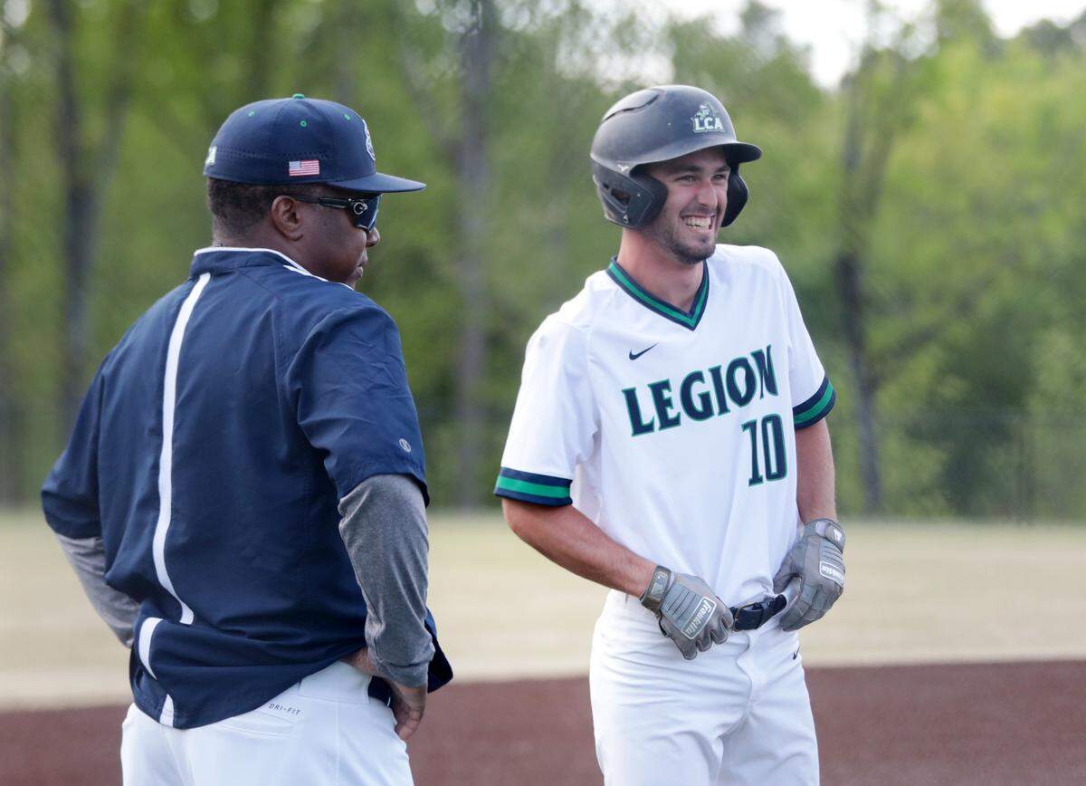 Legion Collegiate’s Cody Craig smiles at teammates in the dugout Friday after making it safely to third base.