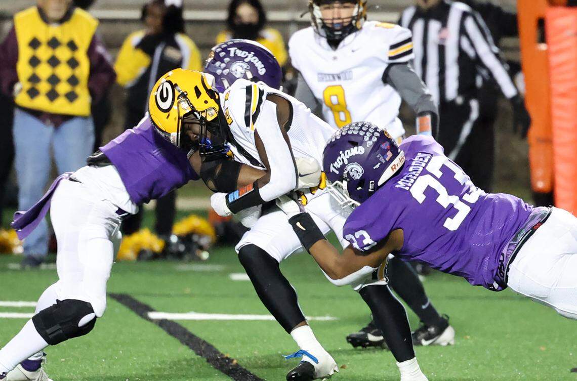 Greenwood’s Trey Crawford is brought down by Northwestern’s Will Massey, left, and Kamerin Mcfadden Friday in Rock Hill, S.C.