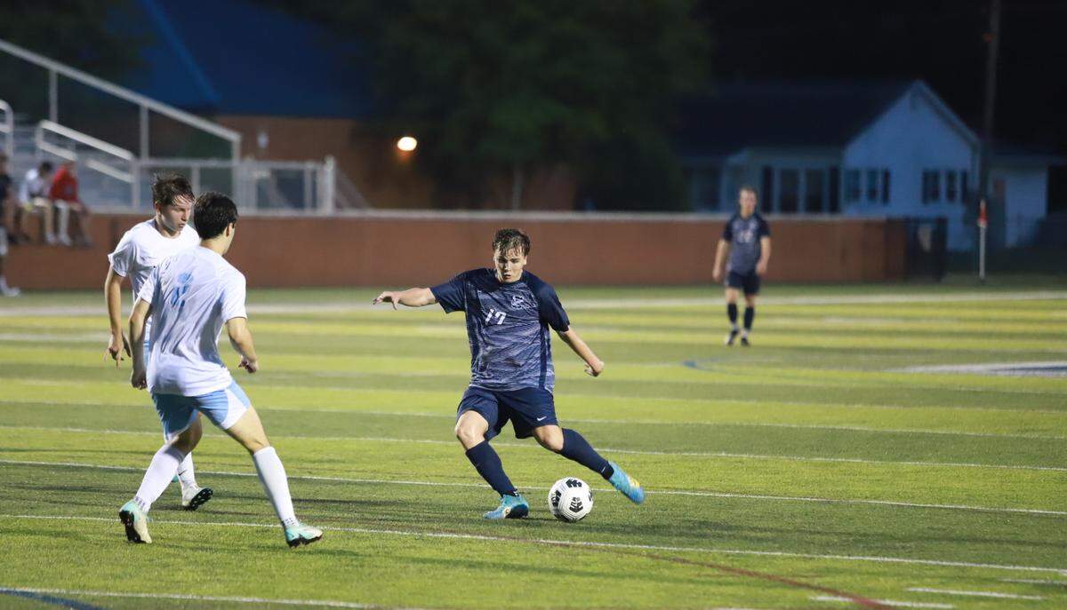 Senior Landon Sykes (17, dark blue) strikes the ball with his left foot for a goal to put Clover up 2-1 in the Blue Eagles’ 3-2 loss to J.L. Mann on May 3.