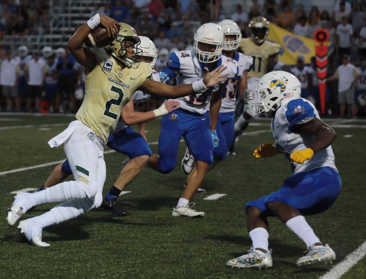 Catawba Ridge quarterback Jadyn Davis (2) avoids Fort Mill’s J.J. Ogwall, right, as the Copperheads and Yellow Jackets meet Friday at Catawba Ridge.