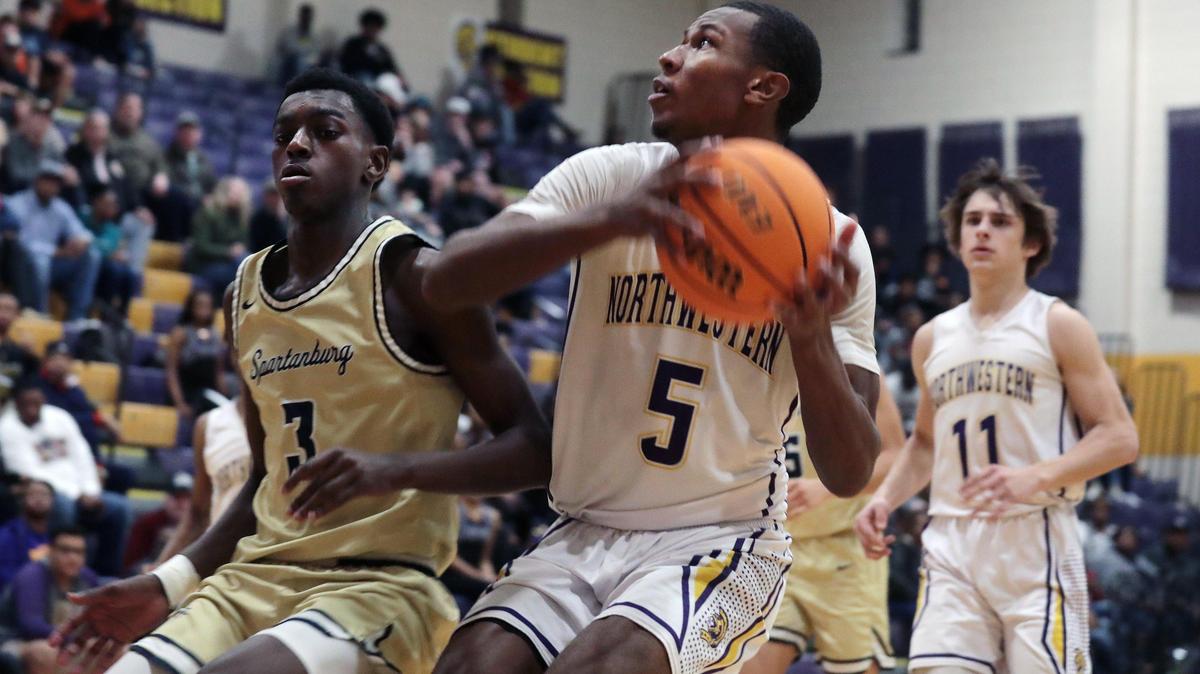 Northwestern’s Ger-Cari Caldwell heads to the basket around Spartanburg’s Kevin Brown at Northwestern High School.
