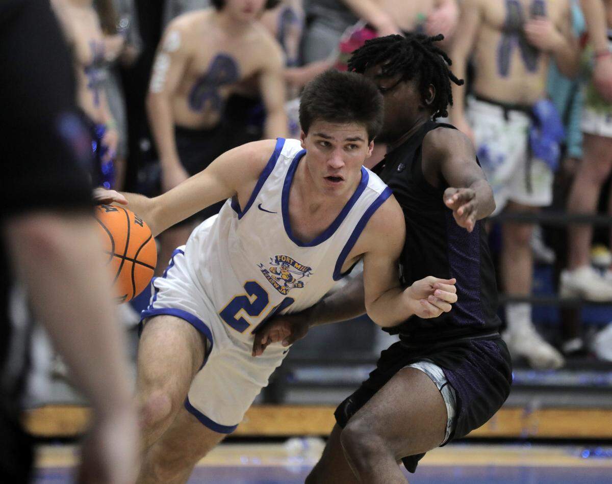 Fort Mill’s Wade Blythe dribbles around Ridgeview’s Nick Letthand Monday as the Yellow Jackets’ boys basketball team takes on the Blazers in Fort Mill.