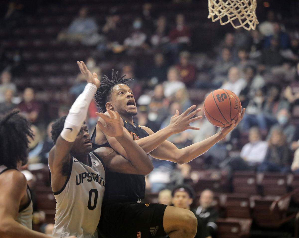 Winthrop’s Michael Anumba heads to the basket around Upstate’s Khydarius Smith (0).