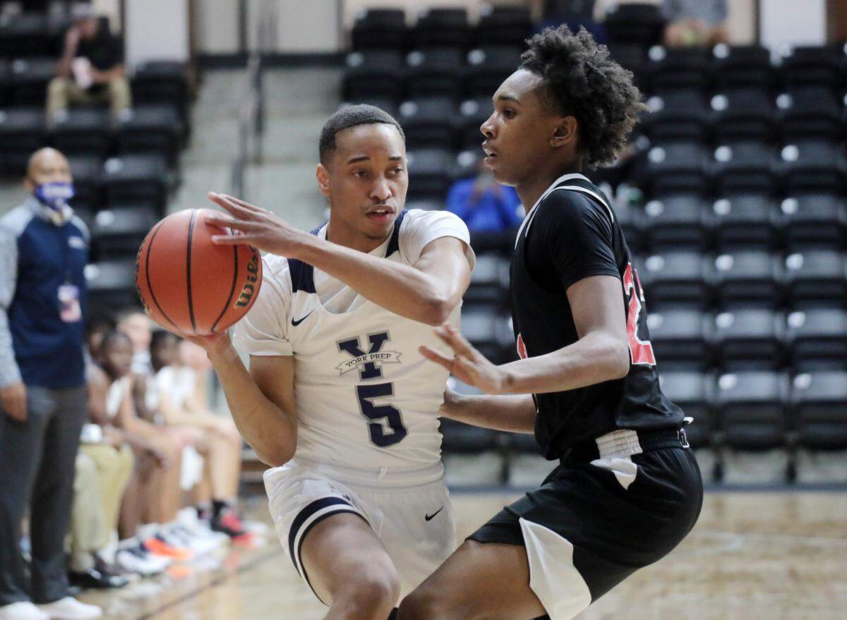 York Prep’s Ladarian McCree, left, looks for an opening around Northside Christian Academy’s Aaron Hall Thursday. The teams competed in the Battle at the Rock High School Basketball Showcase at the Rock Hill Sports and Event Center.