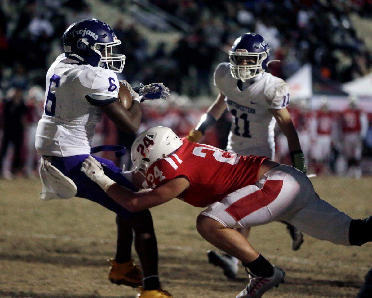 Greenville’s Riggs Faulkenberry (24) tries to stop Northwestern’s Zilon Arnold (6) from scoring a touchdown Friday at the Class 4A Upperstate Championship game in Greenville, S.C.