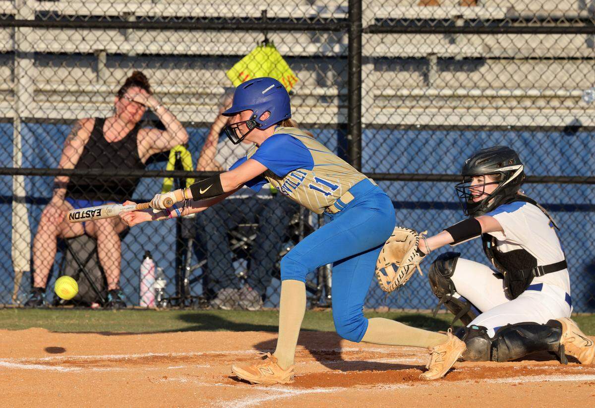 Lewisville’s Sydney Rollins taps the ball as Fort Mill’s Vicki Lott watches the ball Thursday at Fort Mill High School.