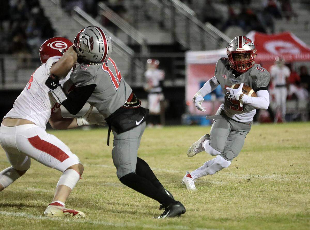South Pointe’s Khyre Rawlinson carries the ball as Demari Kendrick (12) defends against Greenville’s Thomas Edmondson.