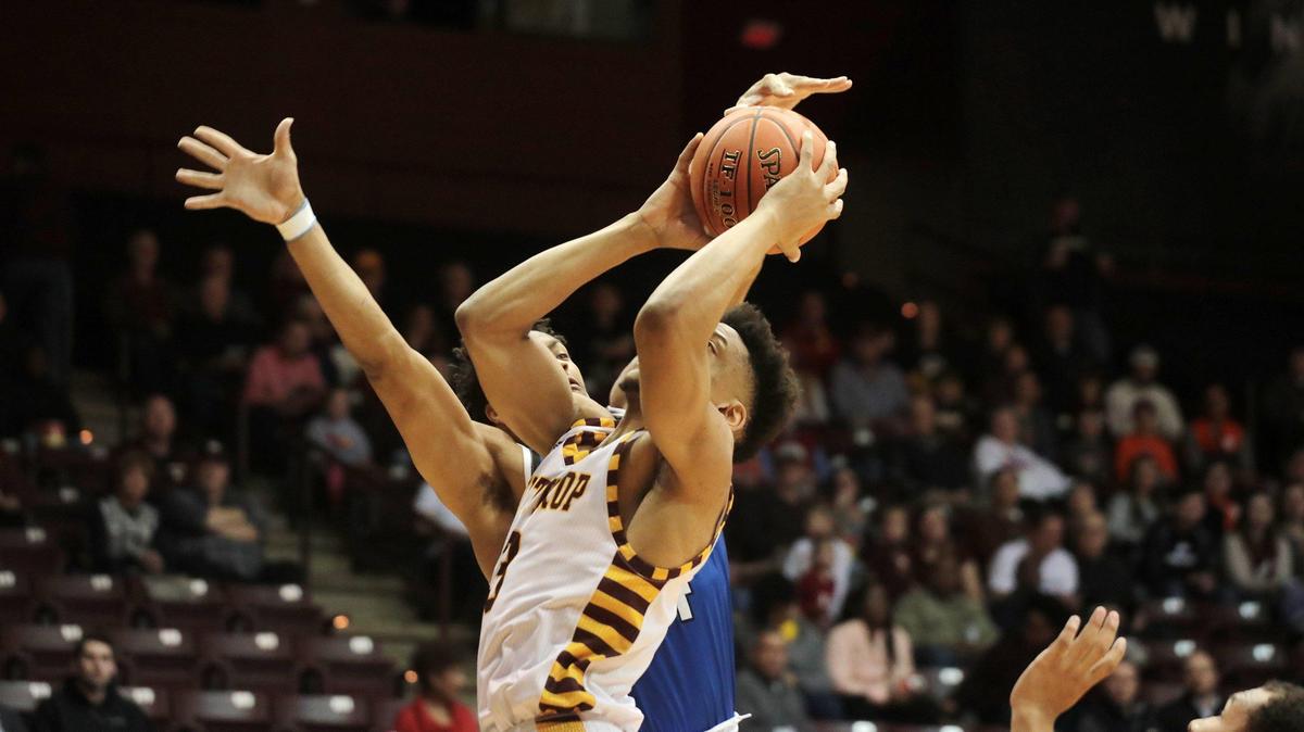 Winthrop’s Micheal Anumba puts up the shot around Hampton’s Ben Stanley.