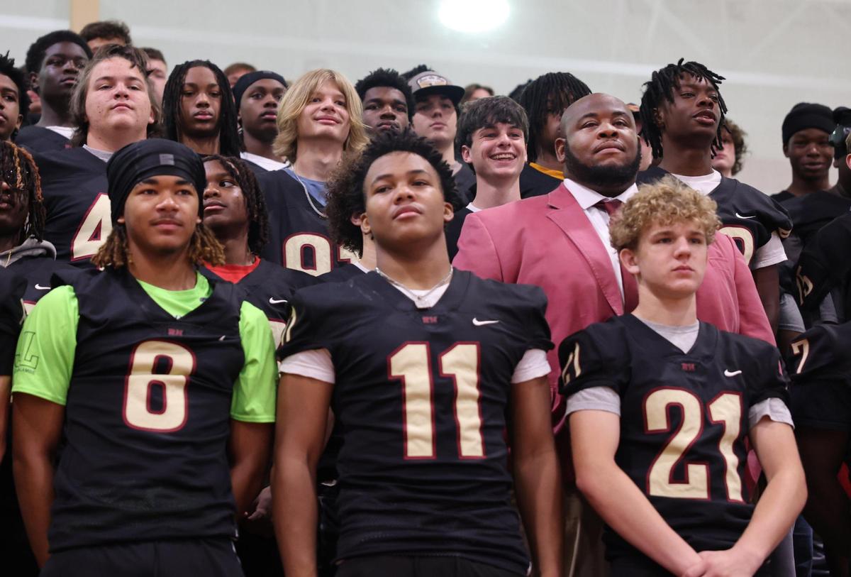 New Rock Hill High School head football coach Leon Boulware stands in a sea of players during his introduction in April.