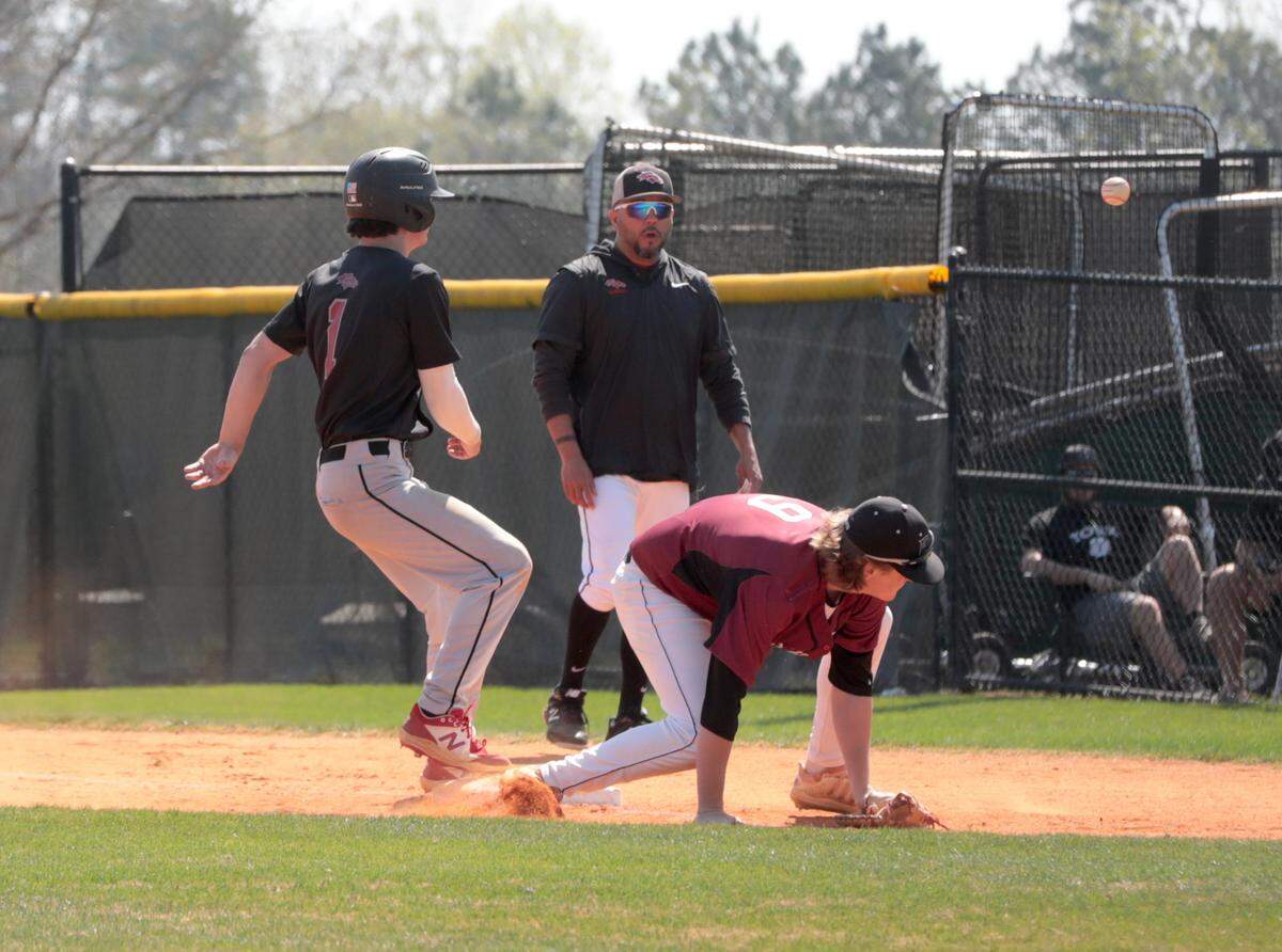 South Pointe’s Cole Montgomery heads back to first base as Rock Hill’s Kyle Wimmer goes for the ball Tuesday in York.