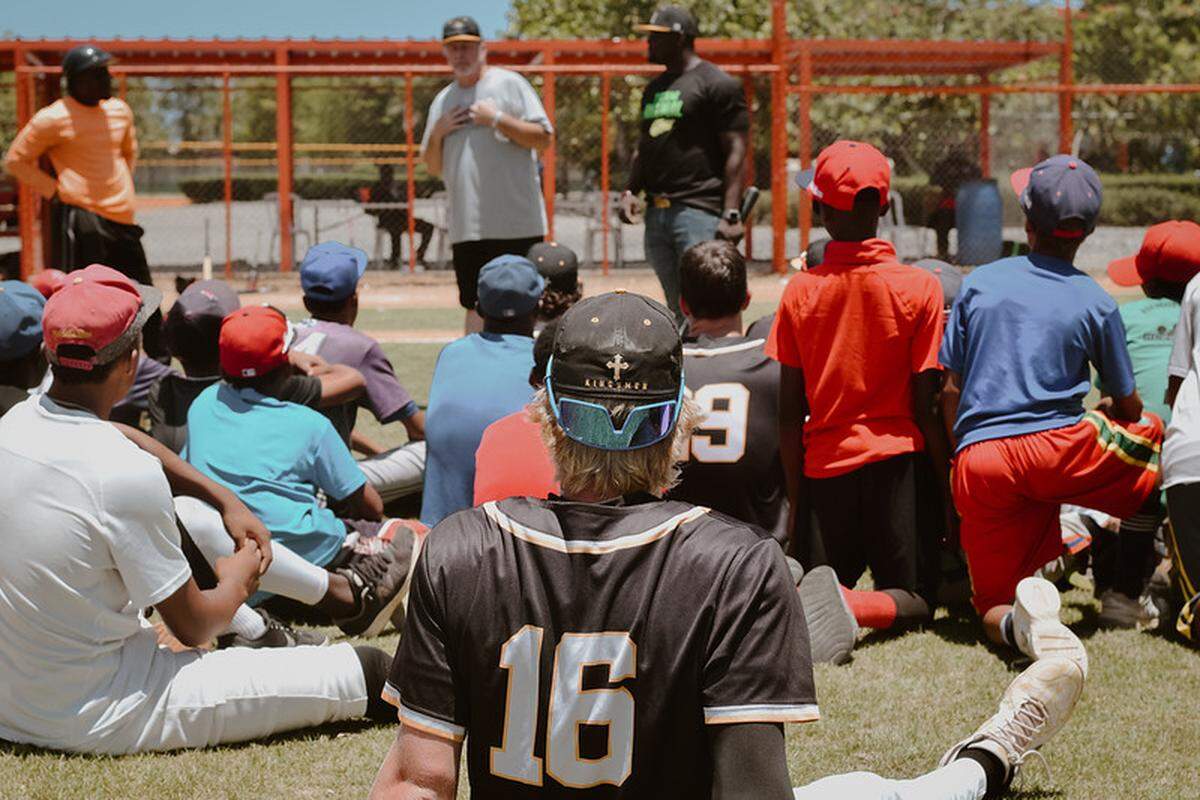 Kingsmen coach Joe Hudak, back, leads a prayer at the end of a baseball game on its annual mission trip.