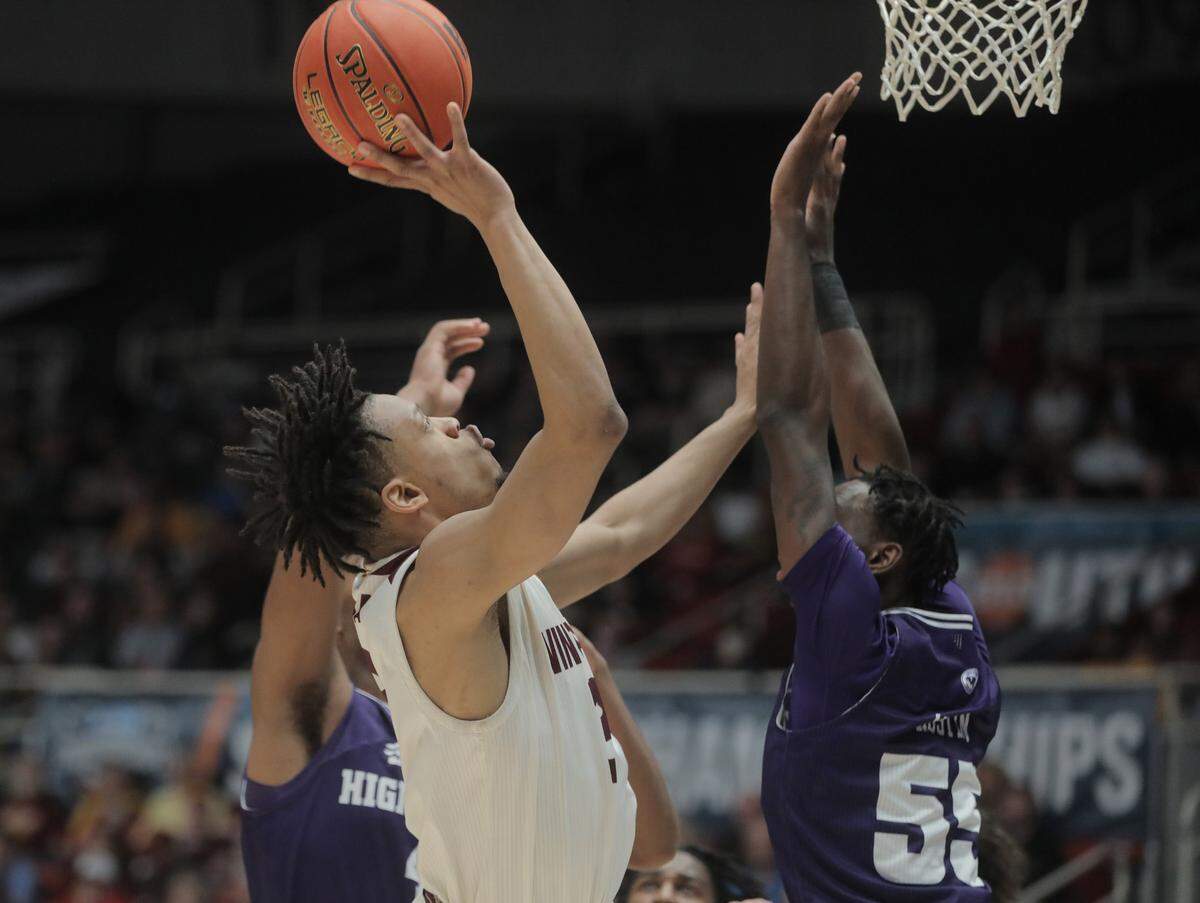 Winthrop’s Michael Anumba, left, shoots over High Point’s Zack Austin.
