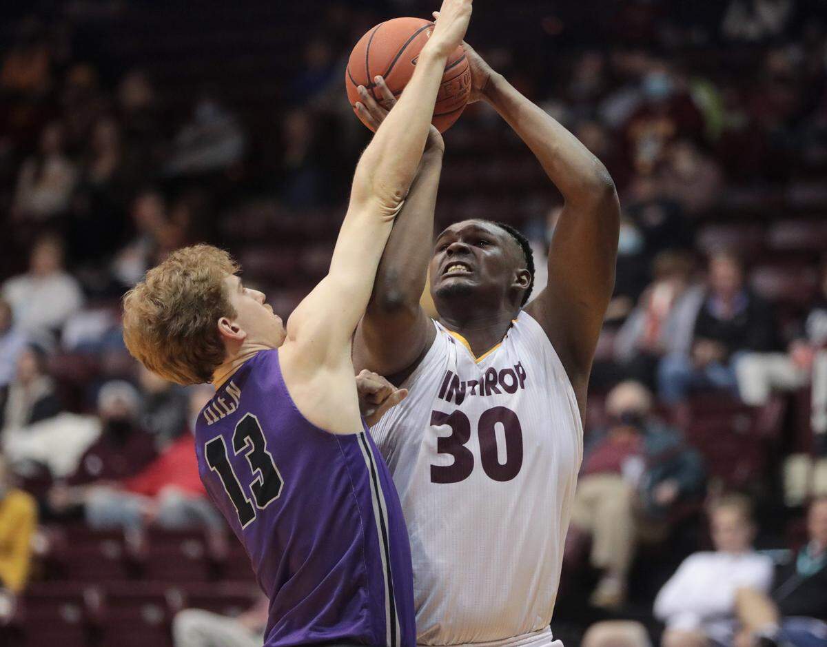 Winthrop’s D.J. Burns Jr. shoots against Furman’s Nate Buss.
