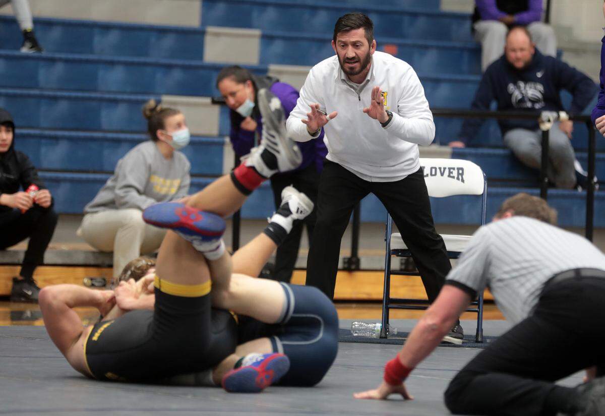 Northwestern High School’s Ryan Whitmore coaches wrestler Kamarien Barnette, who is competing with Clover’s Jadyn Bryant.